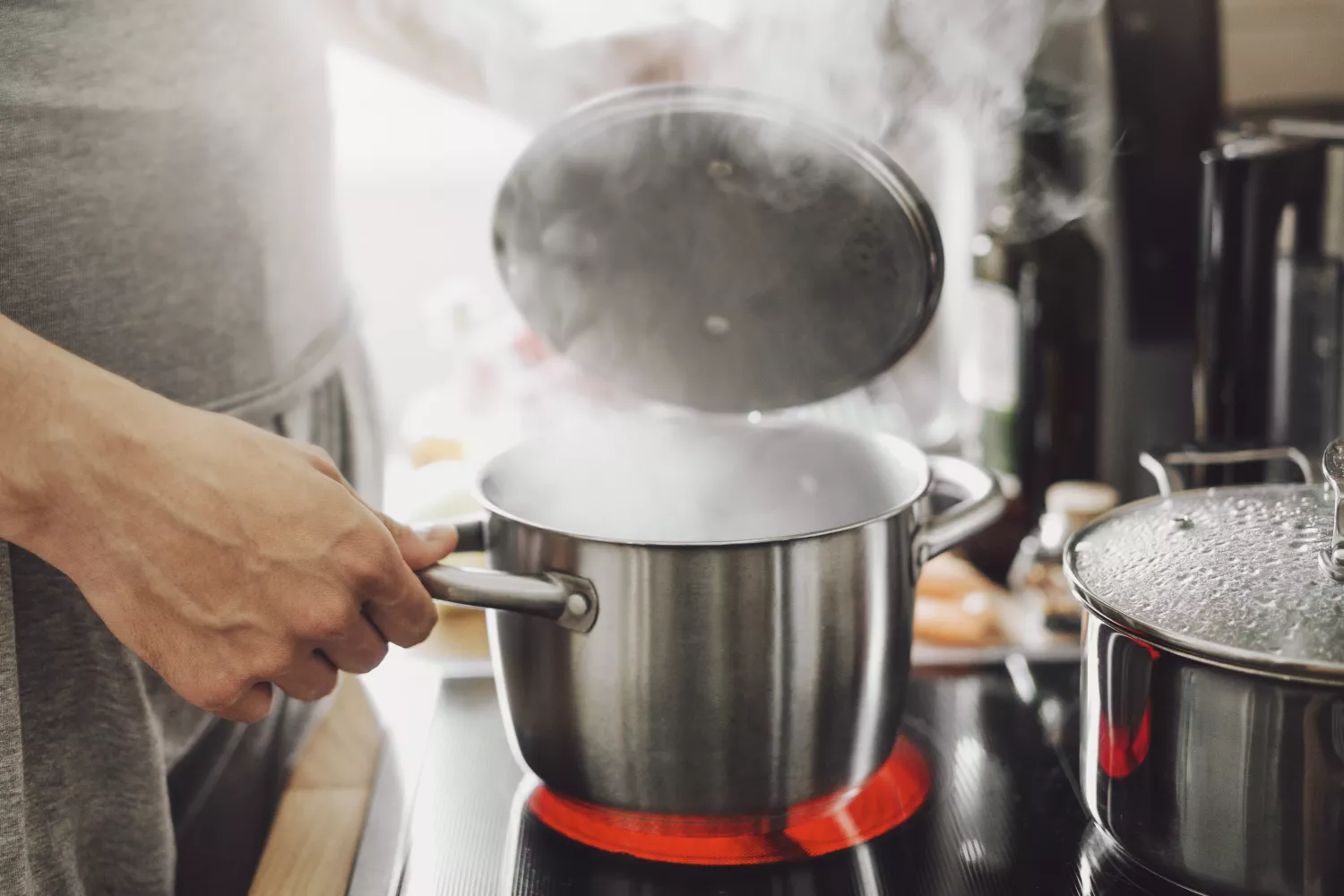 Una persona con dos ollas en la cocina / FREEPIK