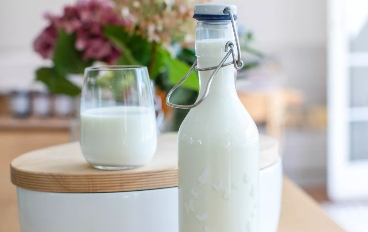 Un vaso junto a una botella de leche / UNSPLASH