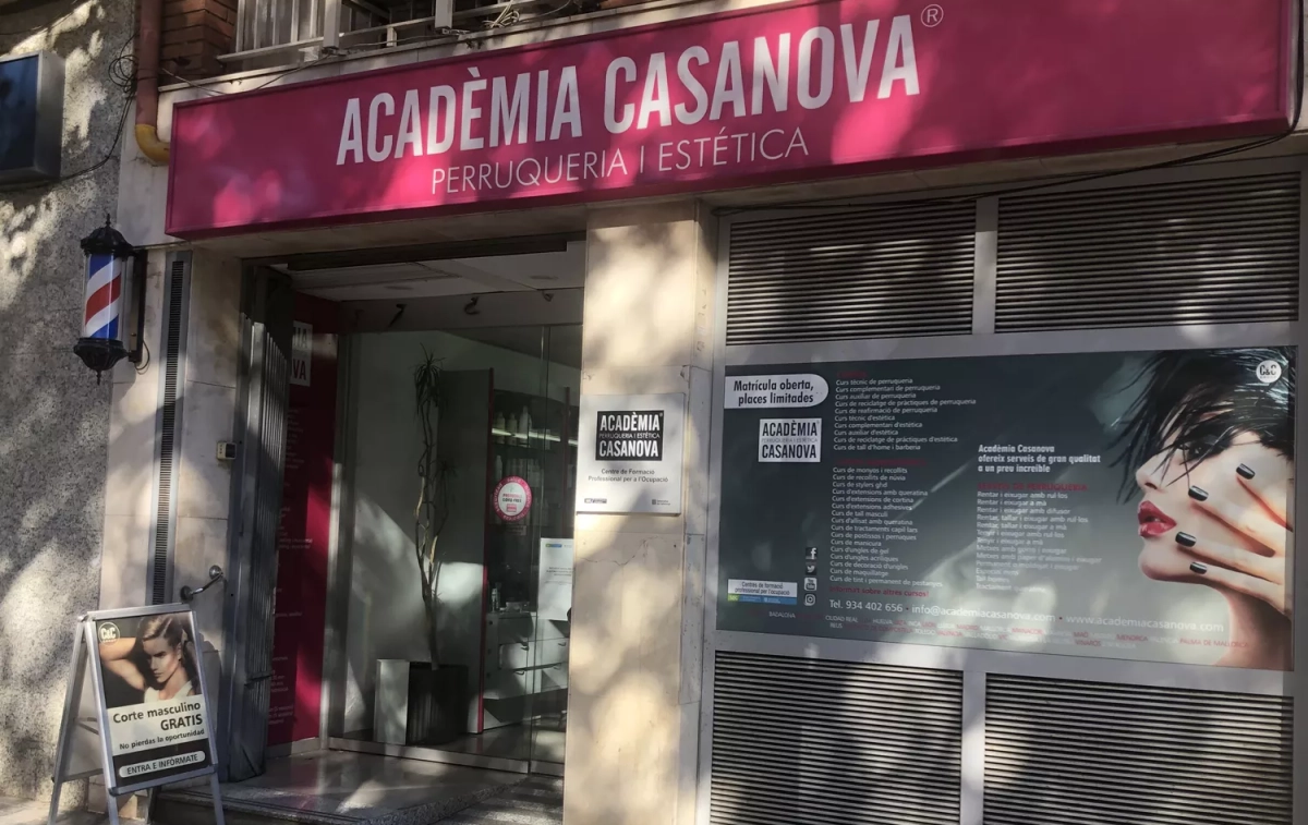 La entrada de la Academia Casanova de peluquería y estética con el letrero que anuncia el corte masculino gratuito en la puerta / CG