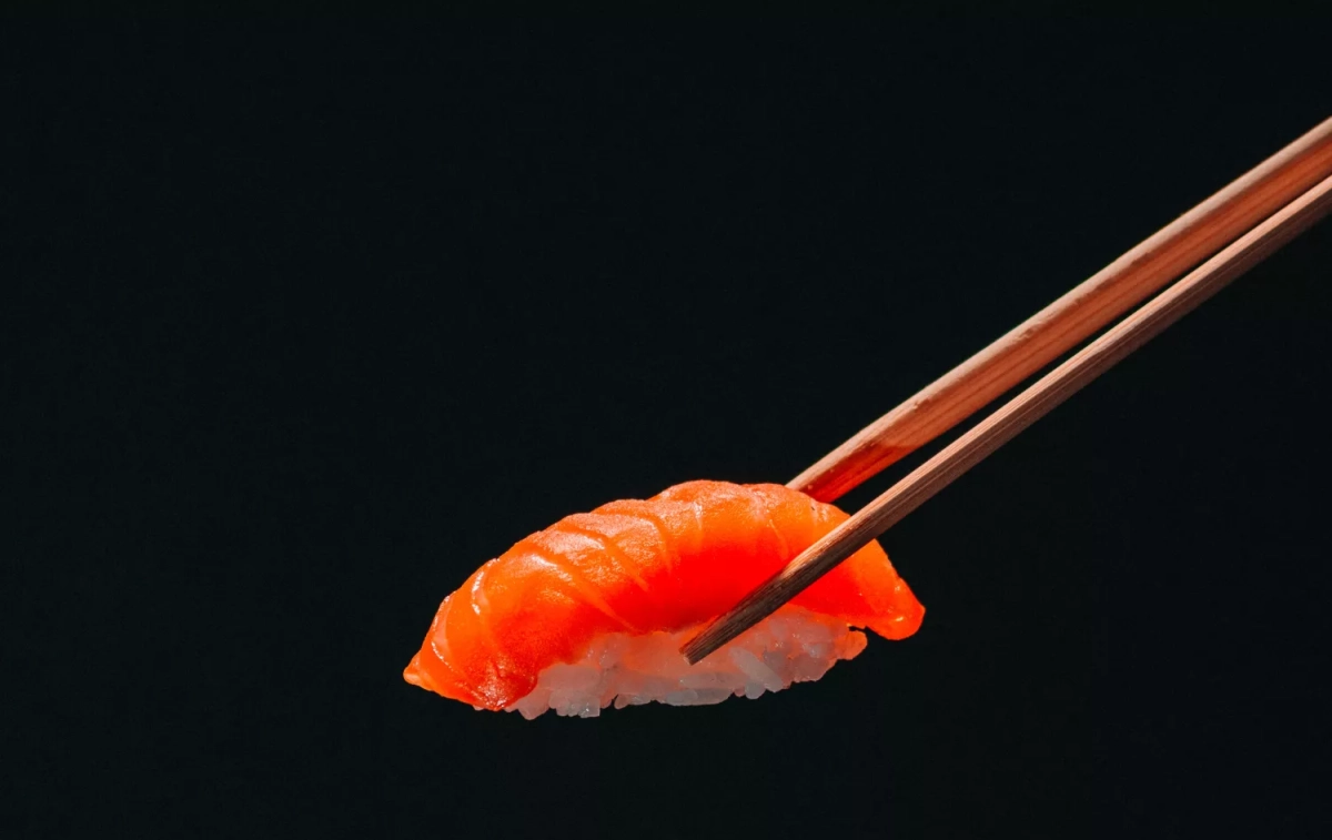 Unos palillos sostienen un nigiri / UNSPLASH