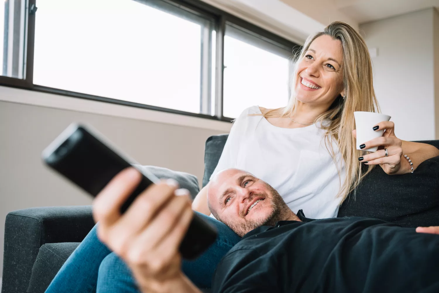 Una pareja ve anuncios desde el sofá de su casa / FREEPIK