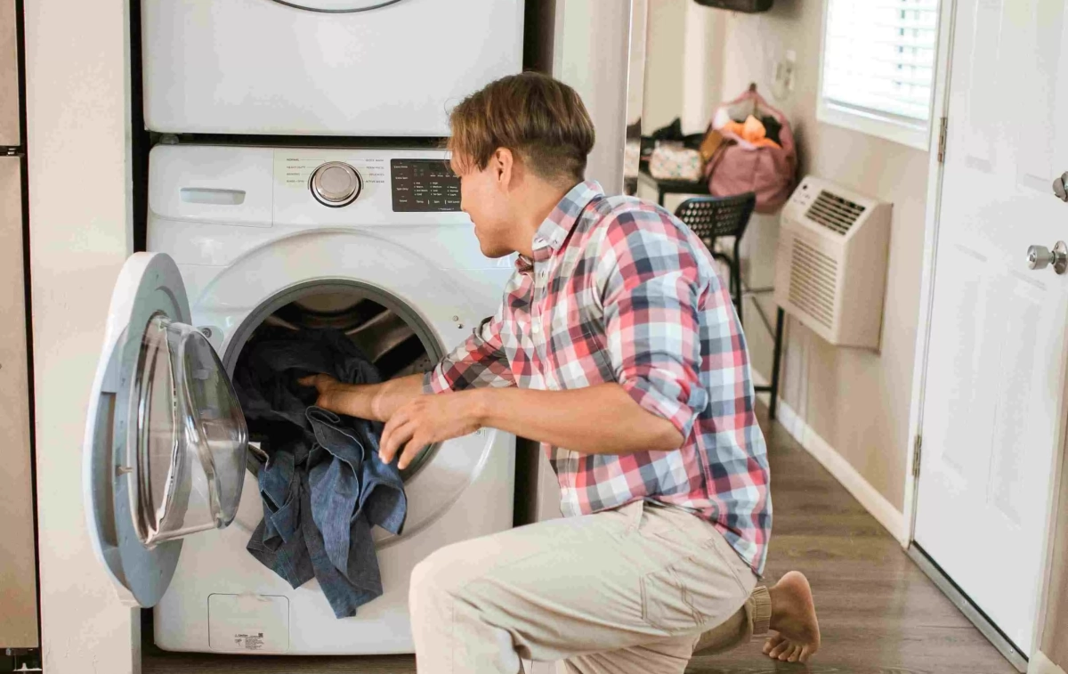 Un chico pone la lavadora sin los calcetines puestos | PEXELS