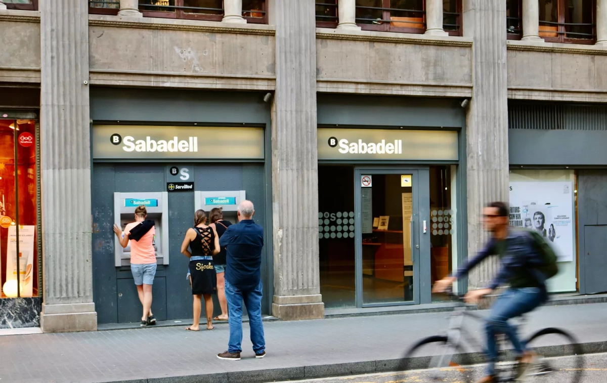 Varias personas frente a una oficina de Sabadell / UNSPLASH