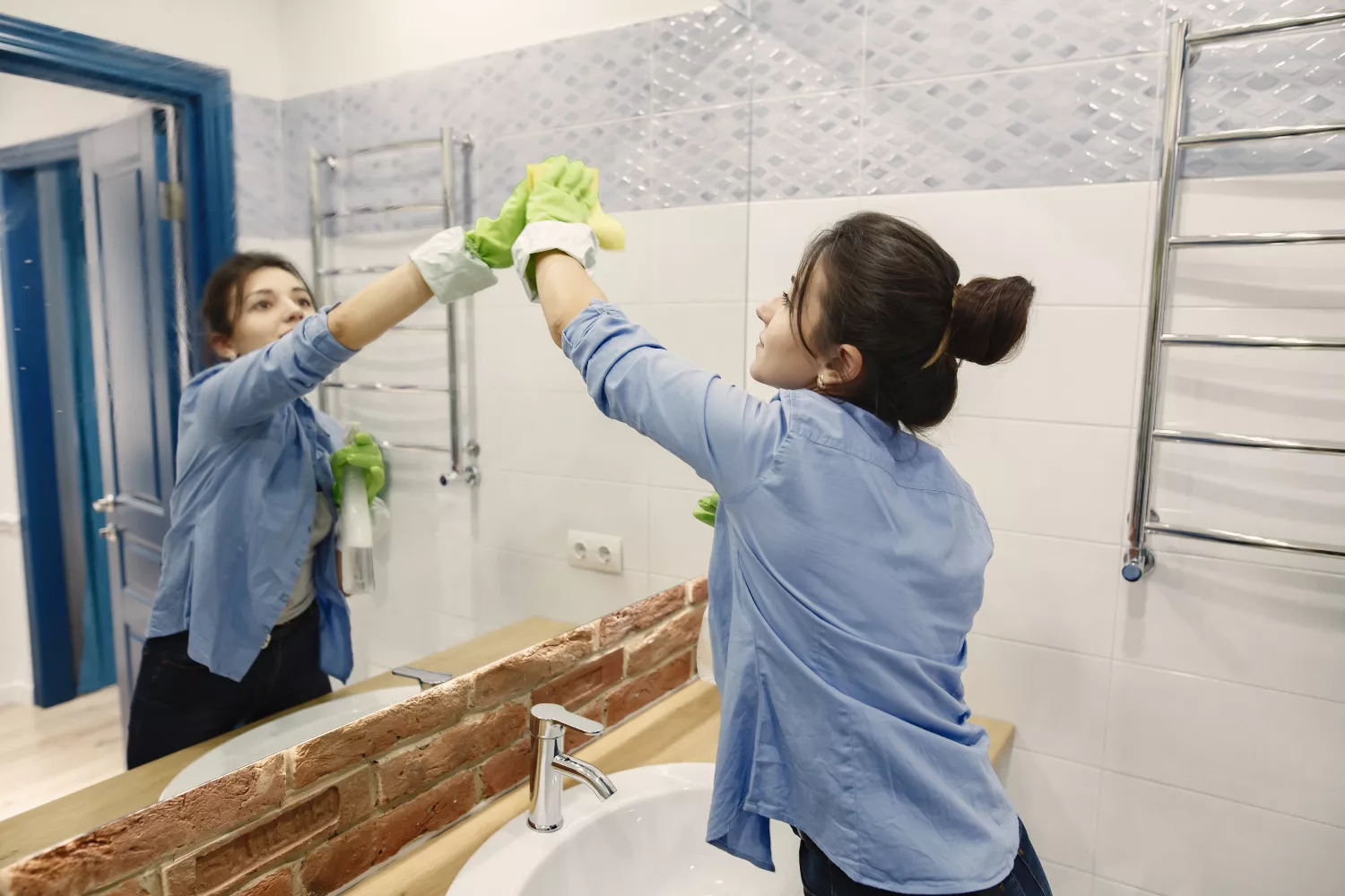 Una mujer limpiando el espejo / FREEPIK