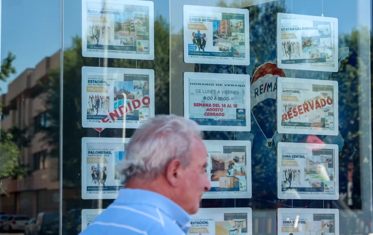 Un hombre camina frente a un escaparate de anuncios de vivienda / Ricardo Rubio - EP