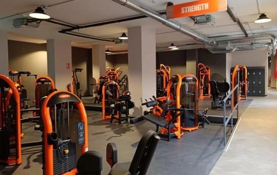 Sala con máquinas de un gimnasio Basic Fit / BASIC FIT Sala con máquinas de un gimnasio Basic Fit / BASIC FIT