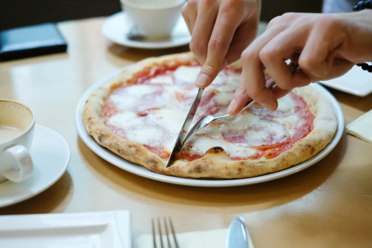 Una persona parte una pizza con cubiertos, algo que, desde ahora, se puede hacer en Telepizza / FREEPIK - @Racool_studio Una persona parte una pizza con cubiertos, algo que, desde ahora, se puede hacer en Telepizza / FREEPIK - @Racool_studio
