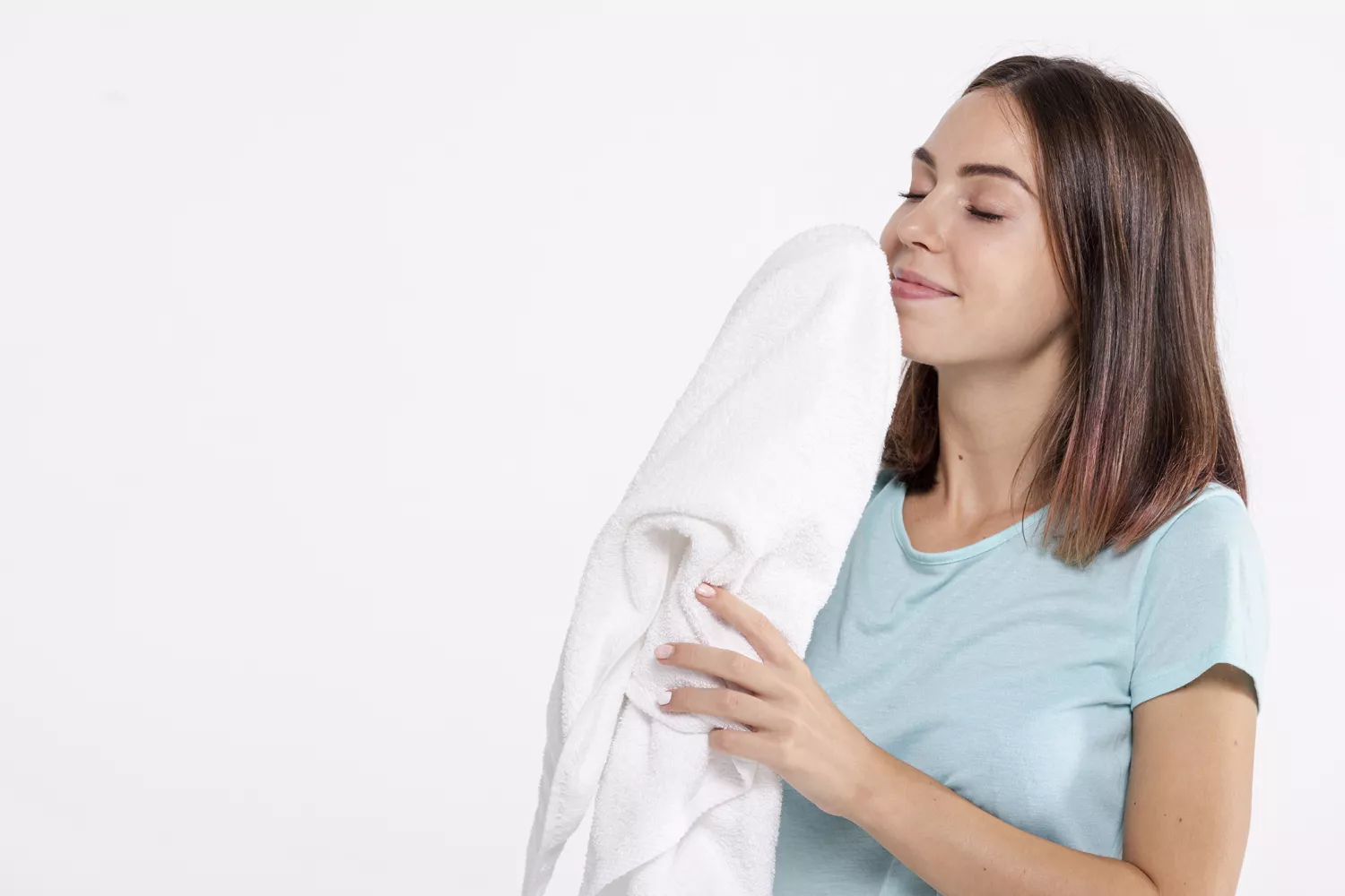 Una persona huele la ropa recién lavada con un suavizante parecido al de Mercadona / FREEPIK