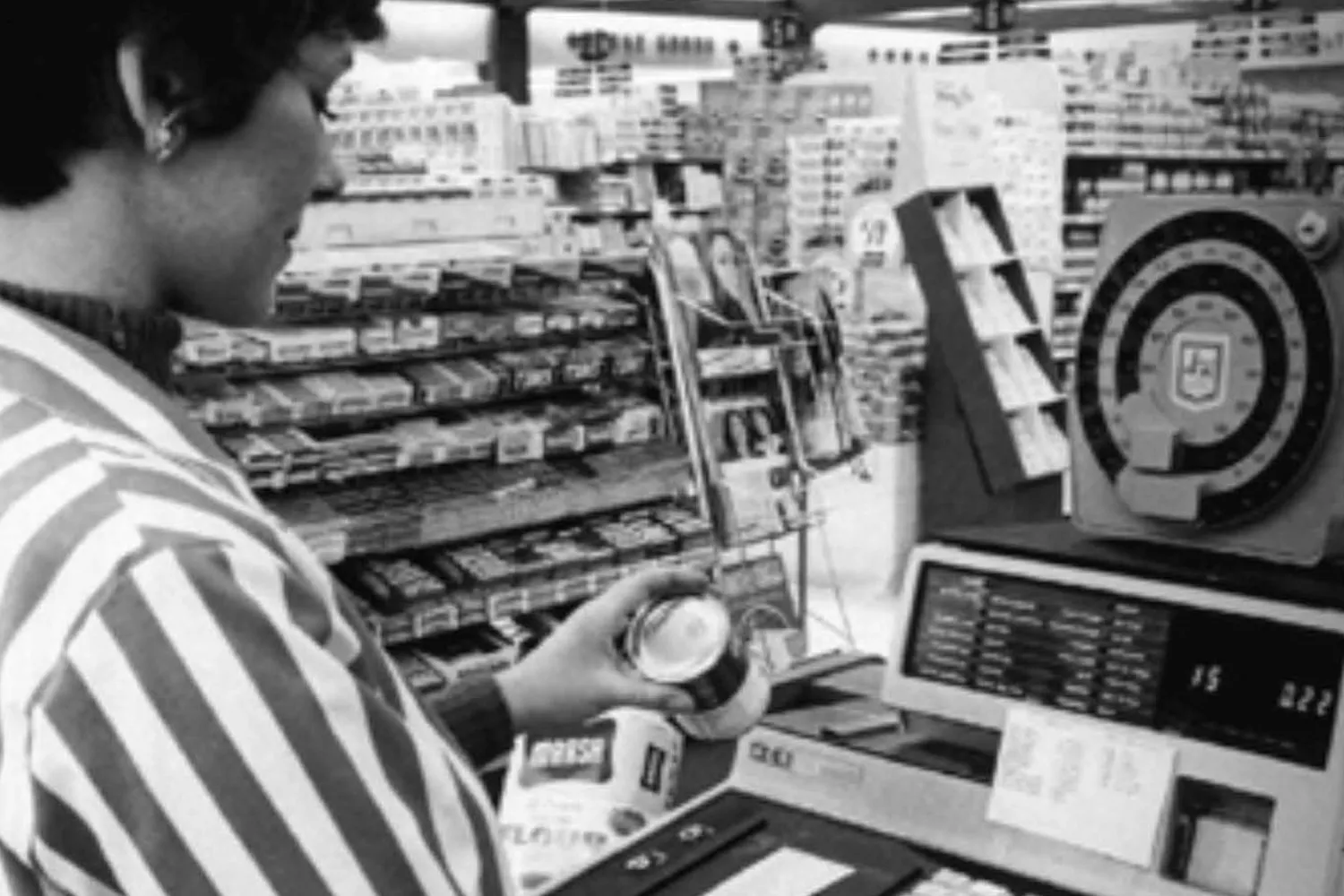 Una cajera mira un código de barras en un supermercado / AECOC