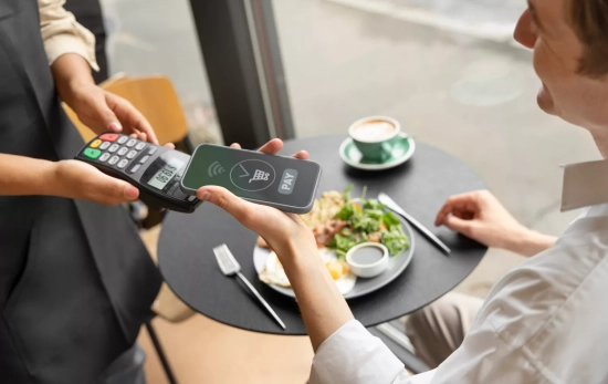 Una persona paga con su móvil en un restaurante / FREEPIK Una persona paga con su móvil en un restaurante / FREEPIK