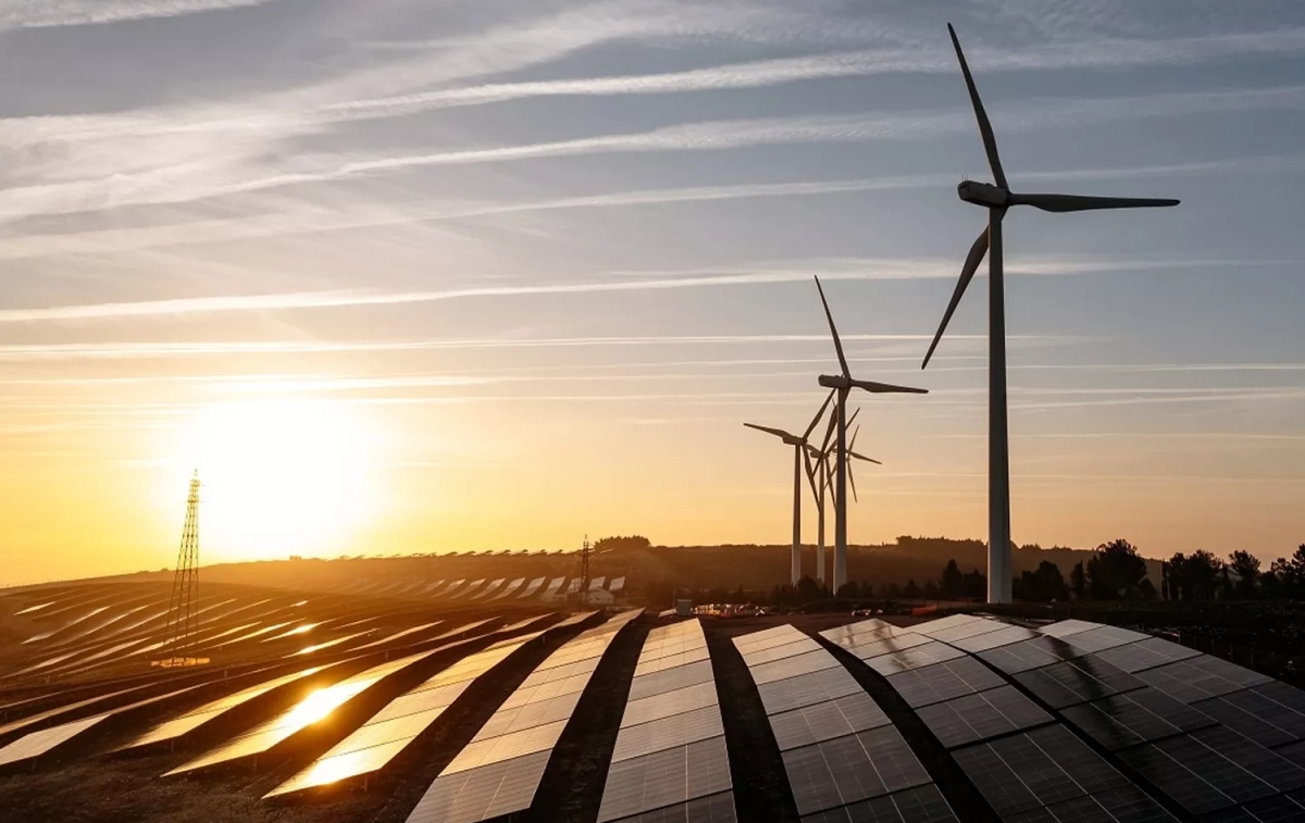 Unos molinos y la luz del sol reflejada en una instalación de placas solares / EDP RENEWABLES