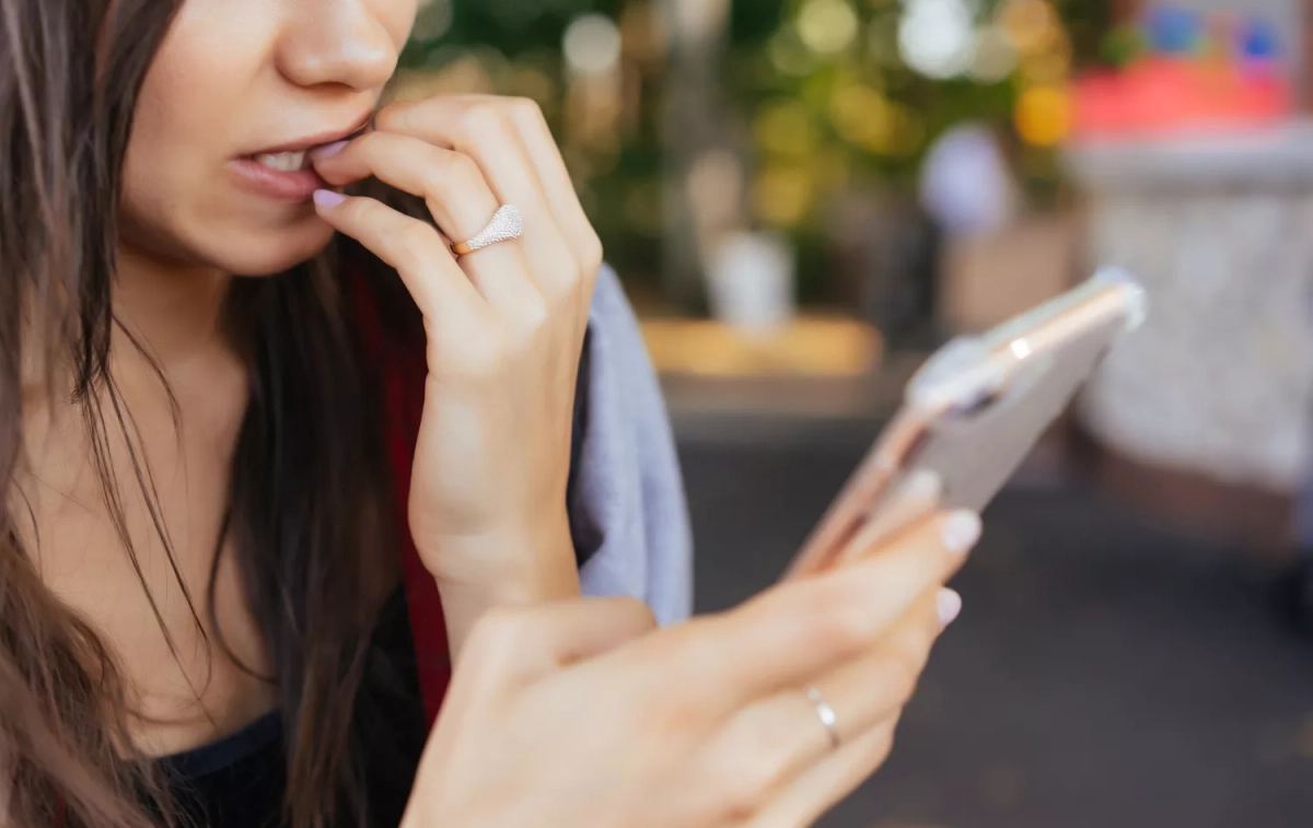 Una mujer mira su móvil con preocupación / FREEPIK - @teksomolika