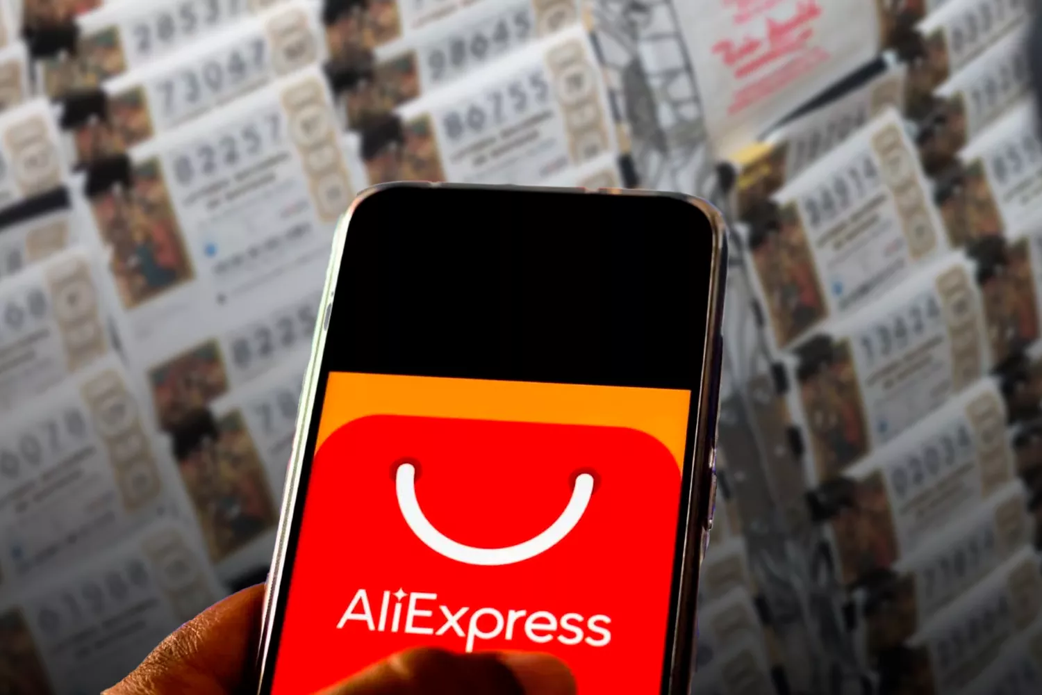 Un móvil con la aplicación de AliExpress y números de lotería / Montaje CONSUMIDOR GLOBAL