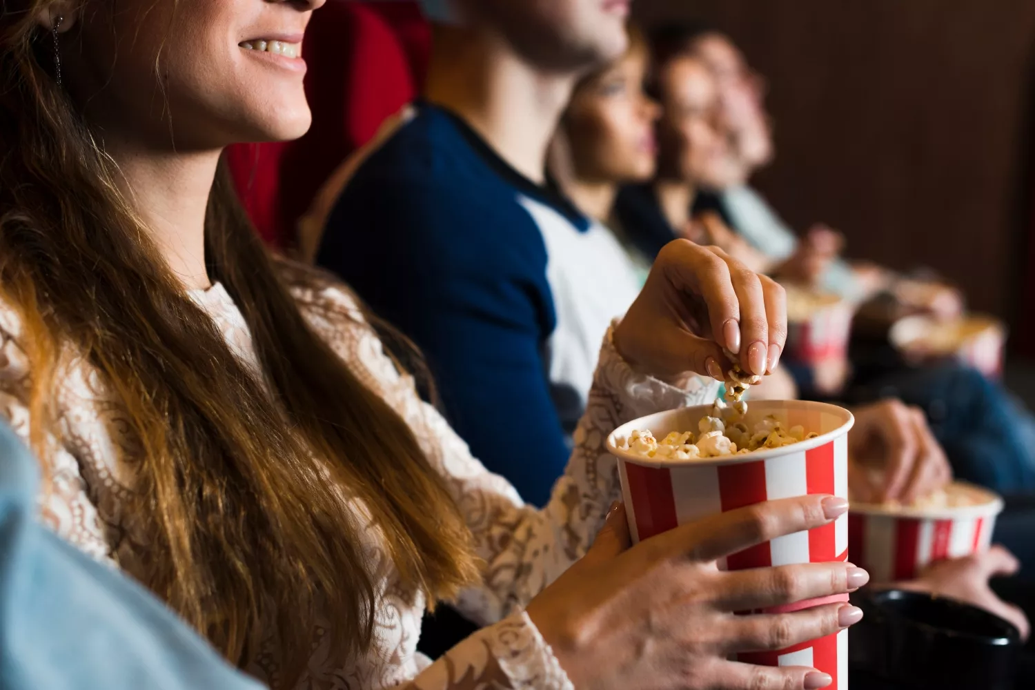 Varios asistentes disfrutan de una película en un cine / FREEPIK Varios asistentes disfrutan de una película en un cine / FREEPIK