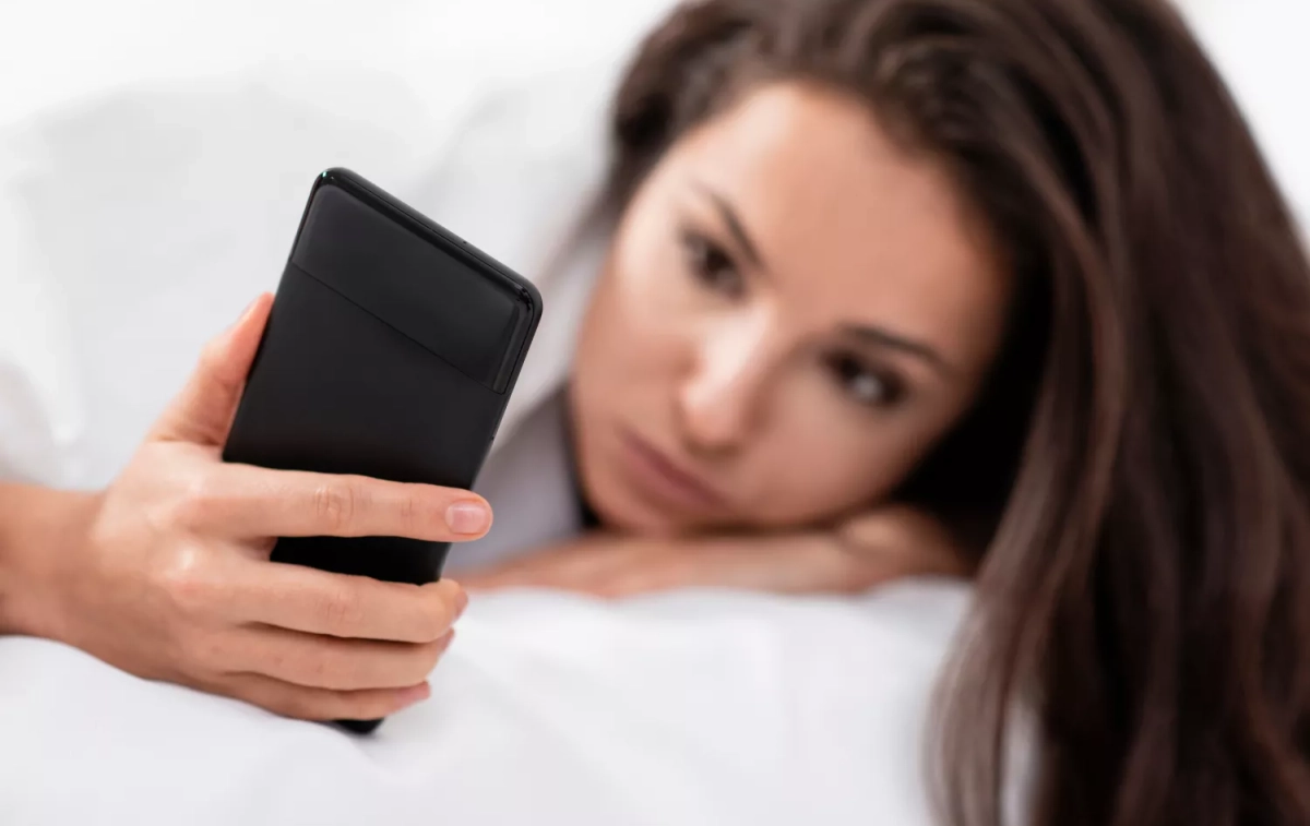 Una chica mira su móvil extrañada / FREEPIK Una chica mira su móvil extrañada / FREEPIK