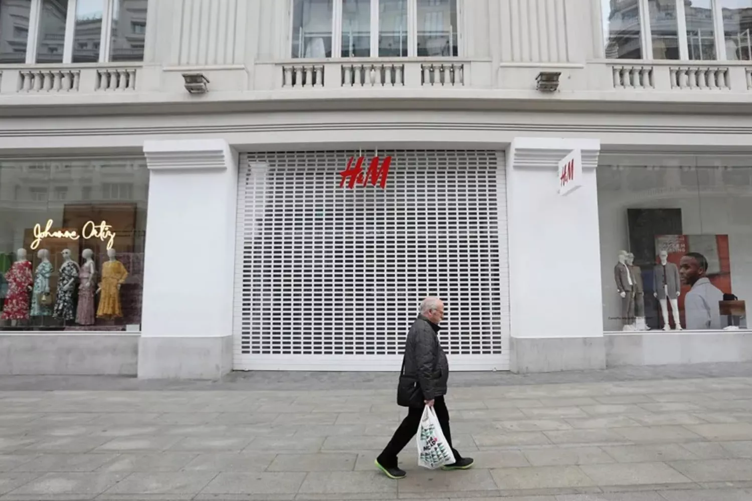 Una persona pasa por delante de una tienda de H&M cerrada / KIKO HUESCA - EFE