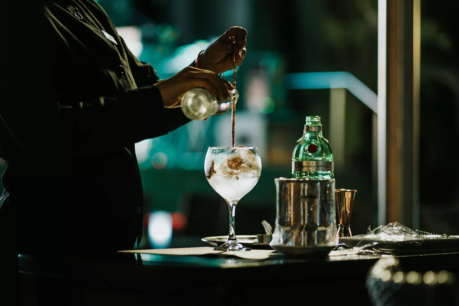 Una persona prepara un gin tonic   UNSPLASH