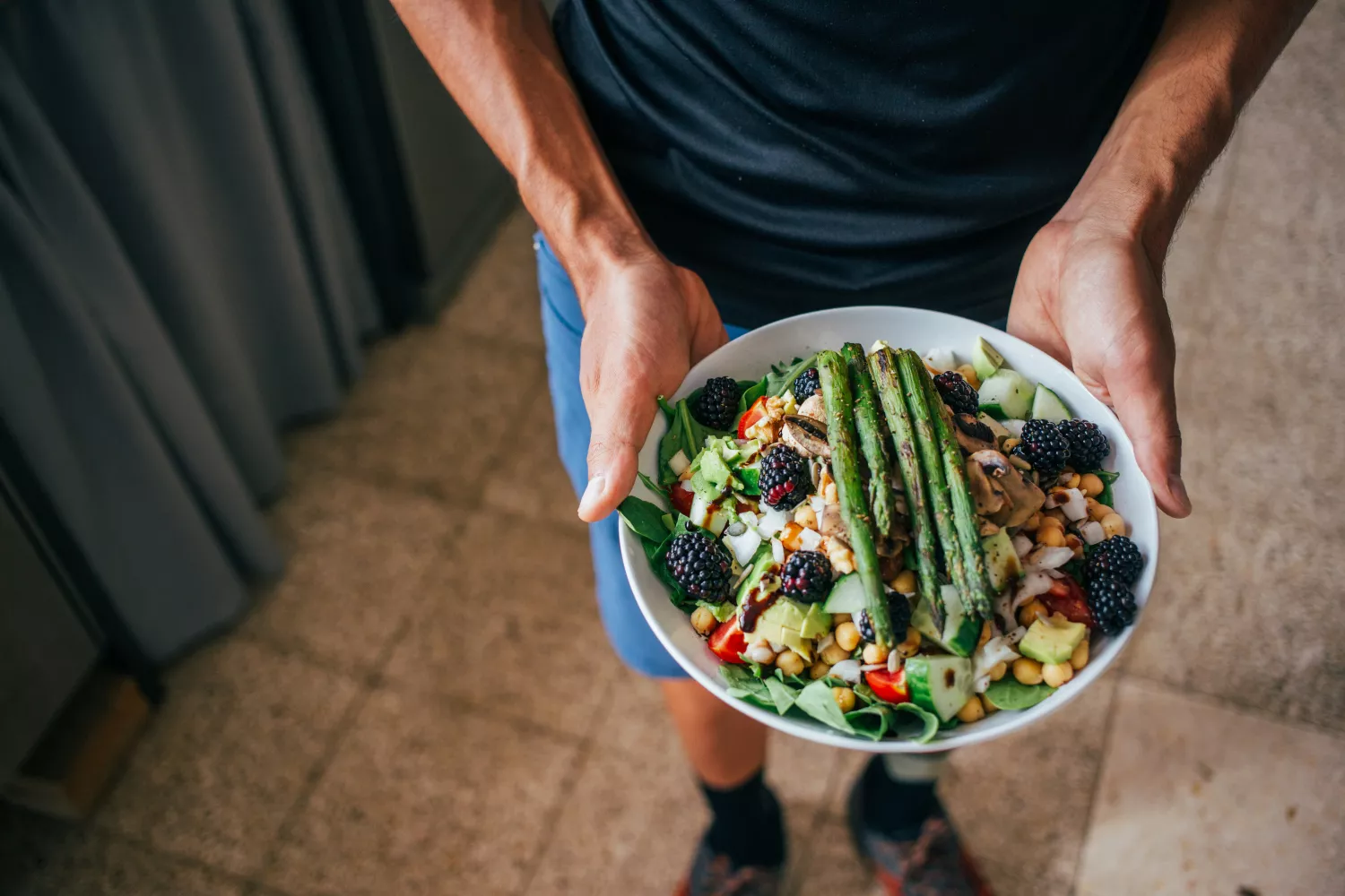 Un deportista con un plato de alimentación plant-based / FREEPIK