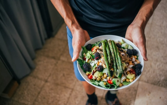 Un deportista con un plato de alimentación plant-based / FREEPIK