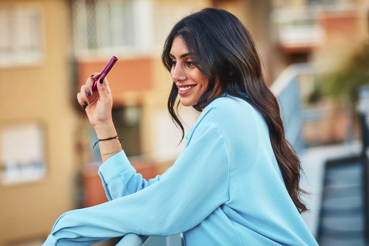 Una mujer con un dispositivo de tabaco calentado / IQOS Una mujer con un dispositivo de tabaco calentado / IQOS