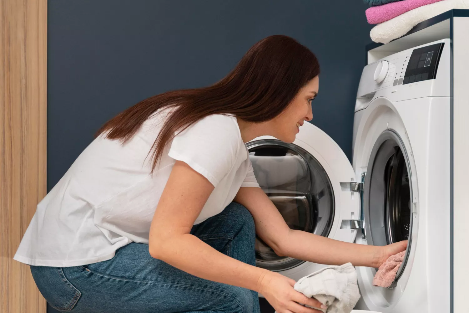 Una chica saca ropa de su lavadora / FREEPIK Una chica saca ropa de su lavadora / FREEPIK