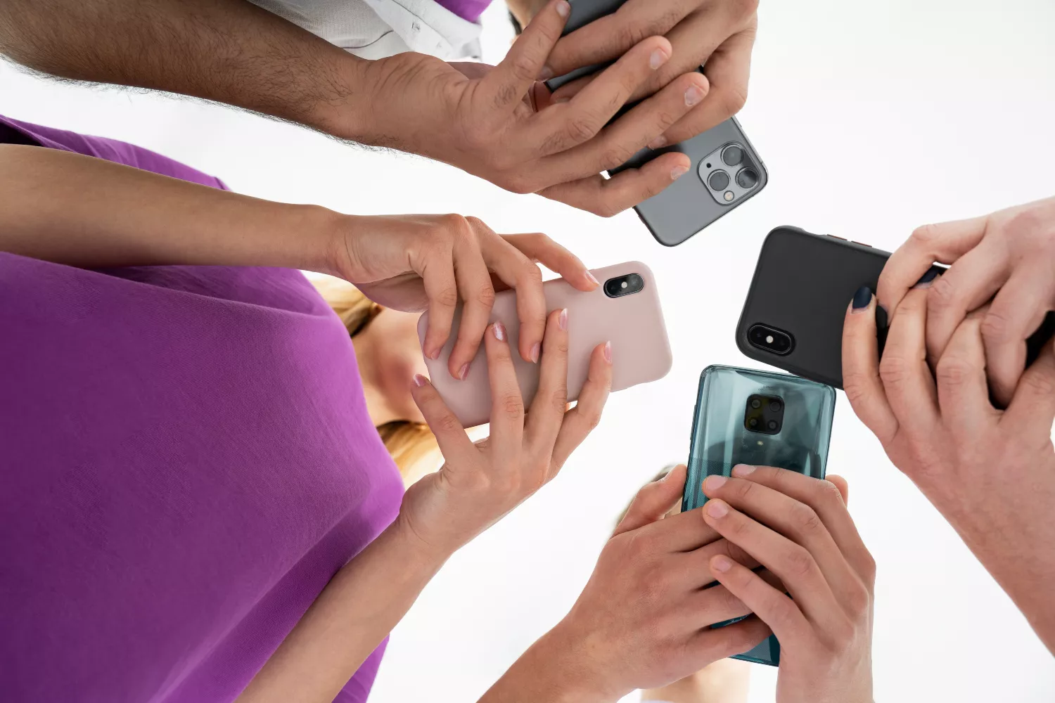 Varias personas usando sus teléfonos móviles sin funda protectora/ FREEPIK