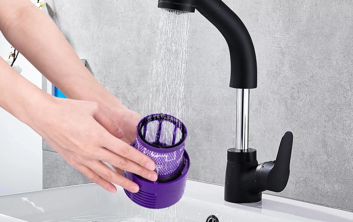 Una persona limpia el filtro de su aspiradora Dyson / DYSON Una persona limpia el filtro de su aspiradora Dyson / DYSON