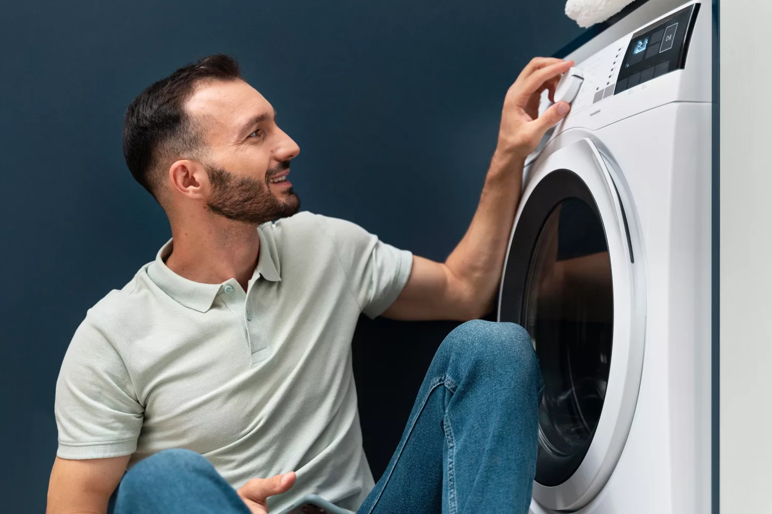 Un hombre pone la lavadora a la hora más barata de la luz / FREEPIK