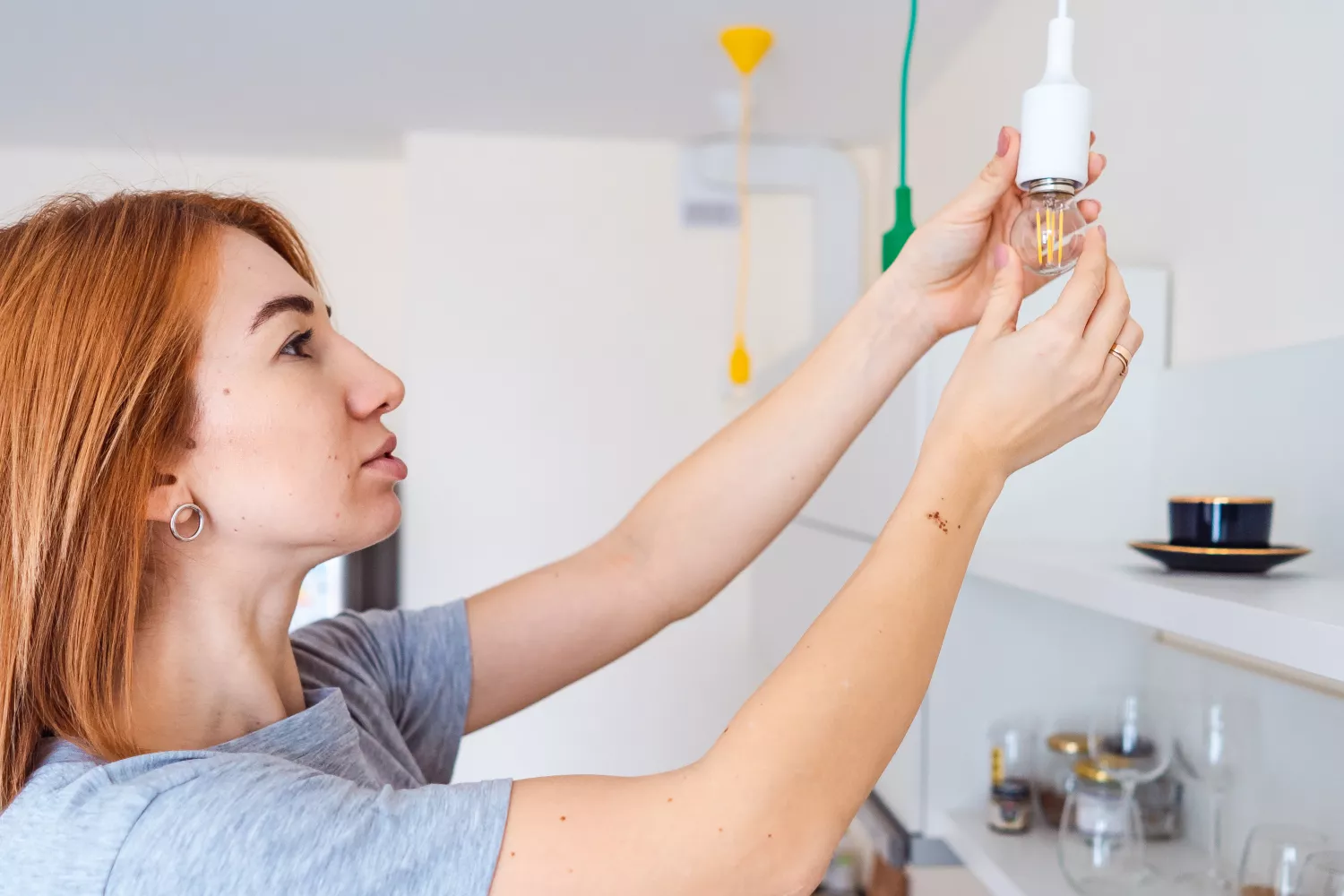 Una mujer instala una bombilla de bajo consumo para ahorrar en la factura de la luz / FREEPIK - @teksomolika Una mujer instala una bombilla de bajo consumo para ahorrar en la factura de la luz / FREEPIK - @teksomolika