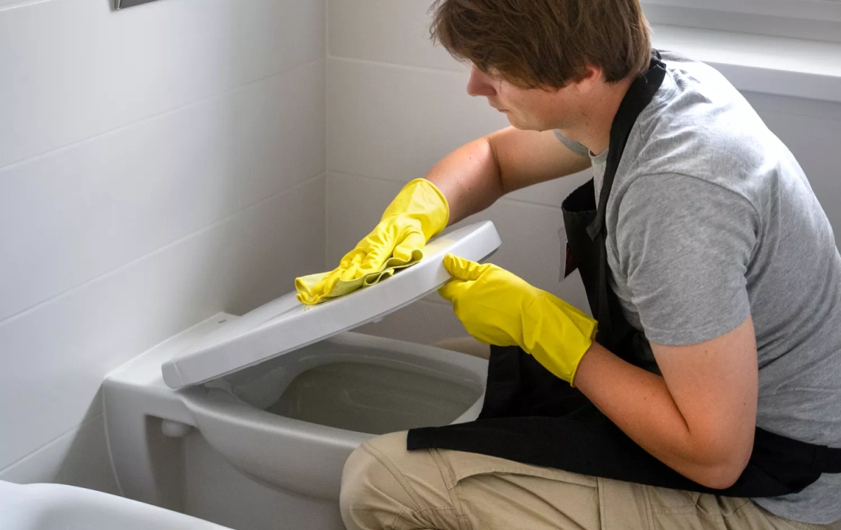 Una persona limpia la tapa del baño / FREEPIK Una persona limpia la tapa del baño / FREEPIK