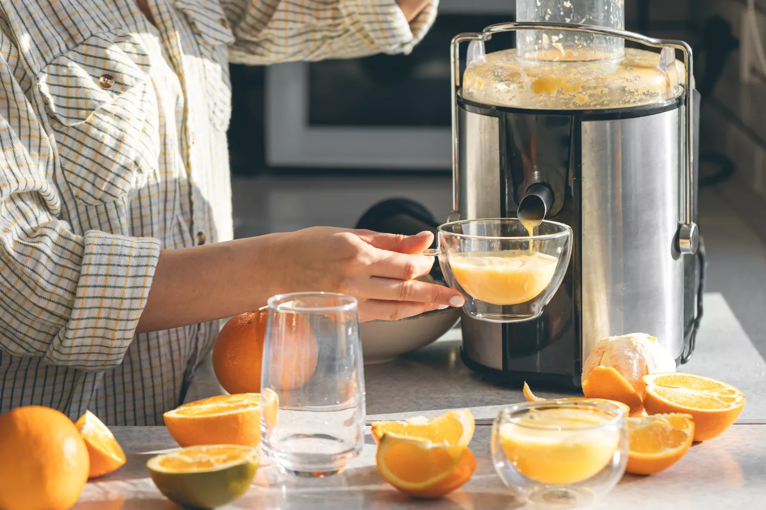 Una persona se hace zumo de naranja en casa / FREEPIK