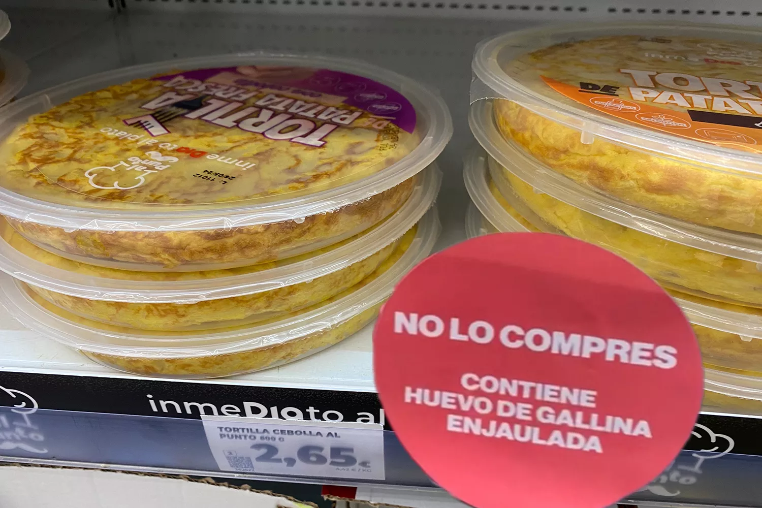 Montaje de la tortilla de supermercados Dia con huevos de gallinas enjauladas y una etiqueta de Observatorio del Bienestar Animal CG