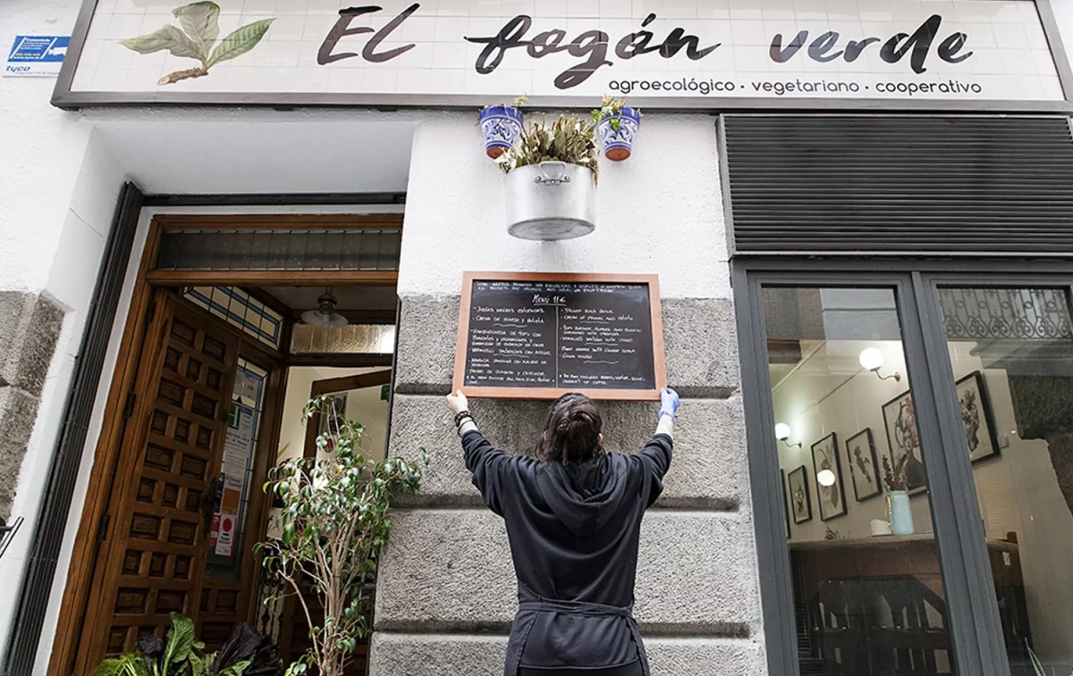Una trabajadora coloca el menú del día en el restaurante El fogón verde / ELFOGÓNVERDE Una trabajadora coloca el menú del día en el restaurante El fogón verde / ELFOGÓNVERDE