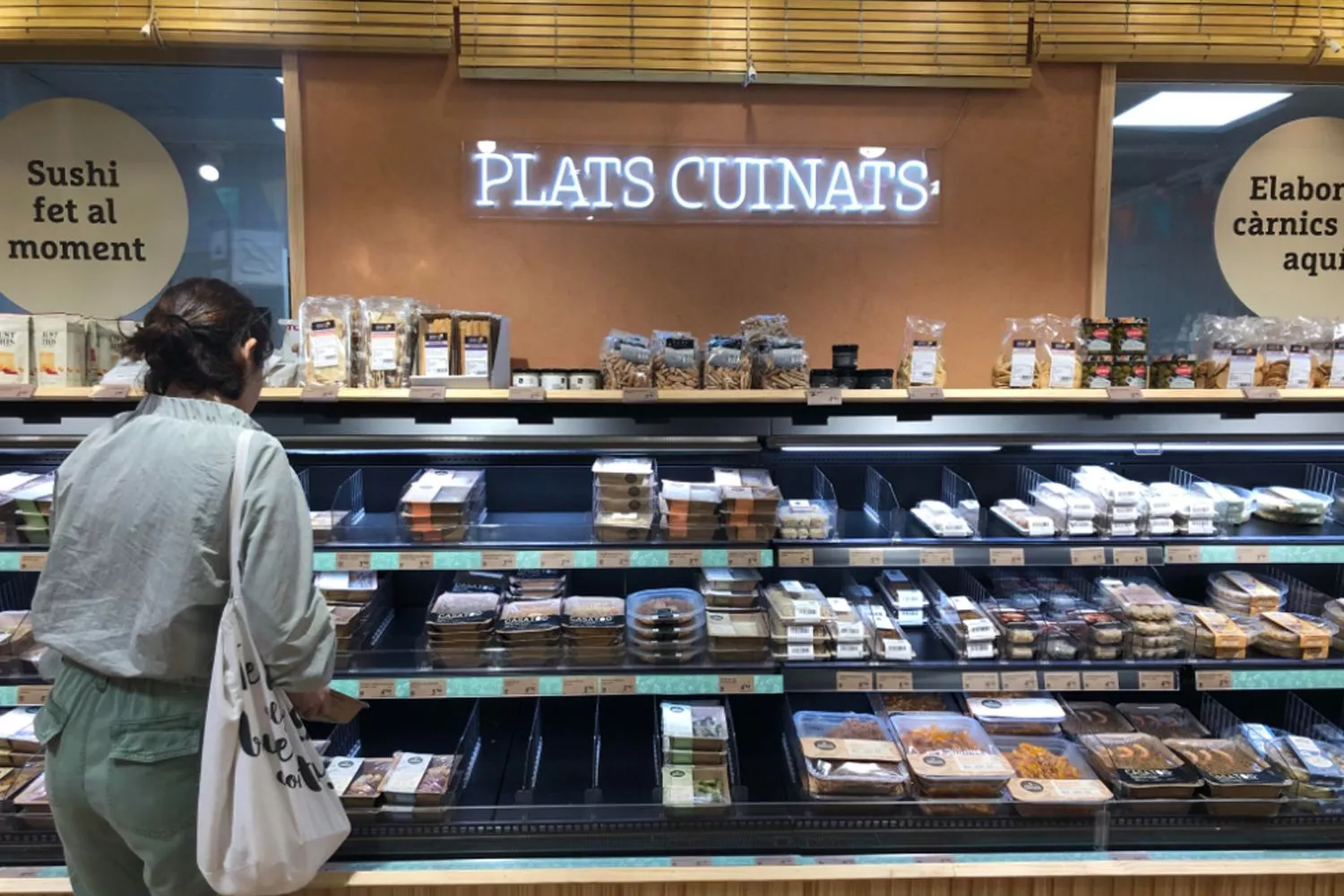 Una consumidora mira los platos preparados de Ametller Origen CG