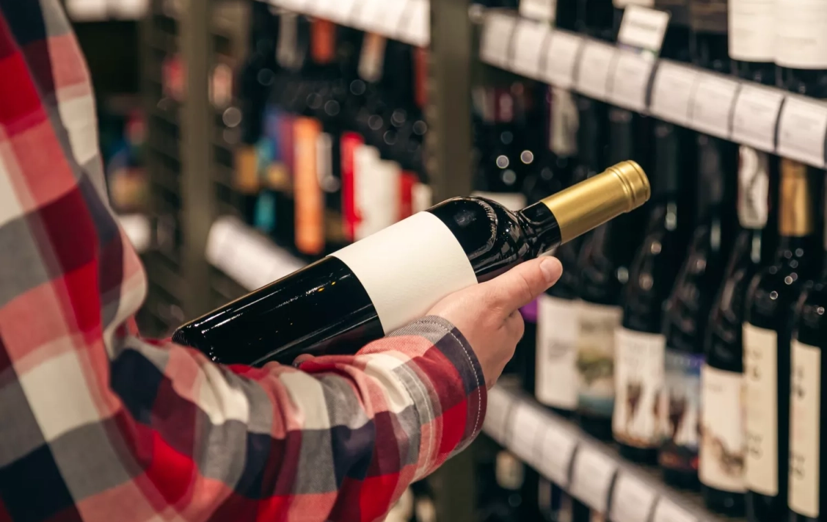 Una persona sostiene una botella de vino tinto joven / FREEPIK - @pvproductions Una persona sostiene una botella de vino tinto joven / FREEPIK - @pvproductions