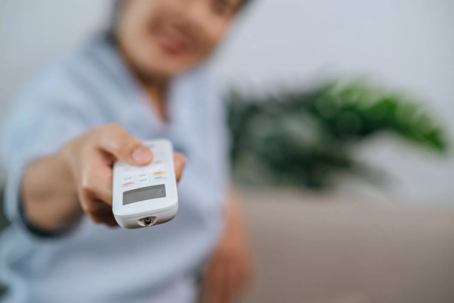 Una persona controla el aire acondicionado a la hora en que la luz es más económica / FREEPIK