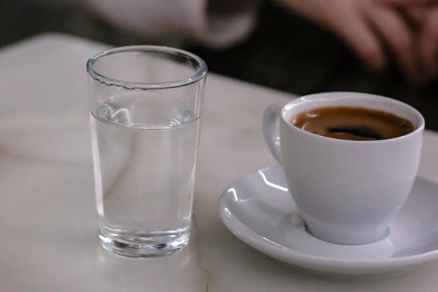 Un café y un vaso de agua   PEXELS