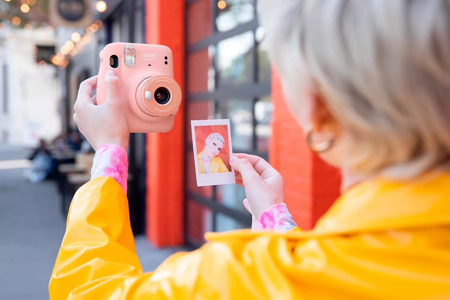 Una persona con una cámara instax mini 11 FUJIFILM