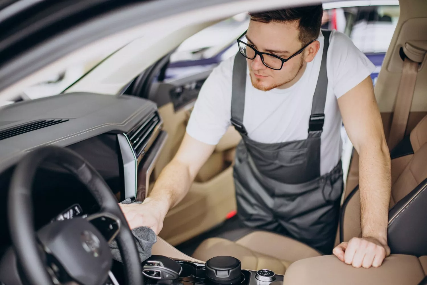 Una persona limpia la tapicería del coche / FREEPIK - senivpetro