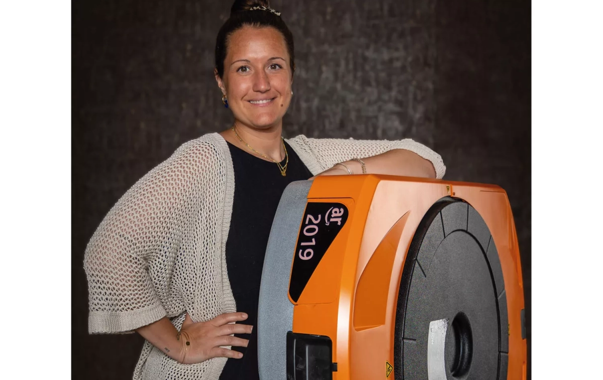 María del Carmen Veuthey junto a Kira, miembro de la unidad móvil robotizada que se usa en algunos centros logísticos de Amazon para desplazar estanterías y mover productos / CEDIDA María del Carmen Veuthey junto a Kira, miembro de la unidad móvil robotizada que se usa en algunos centros logísticos de Amazon para desplazar estanterías y mover productos / CEDIDA