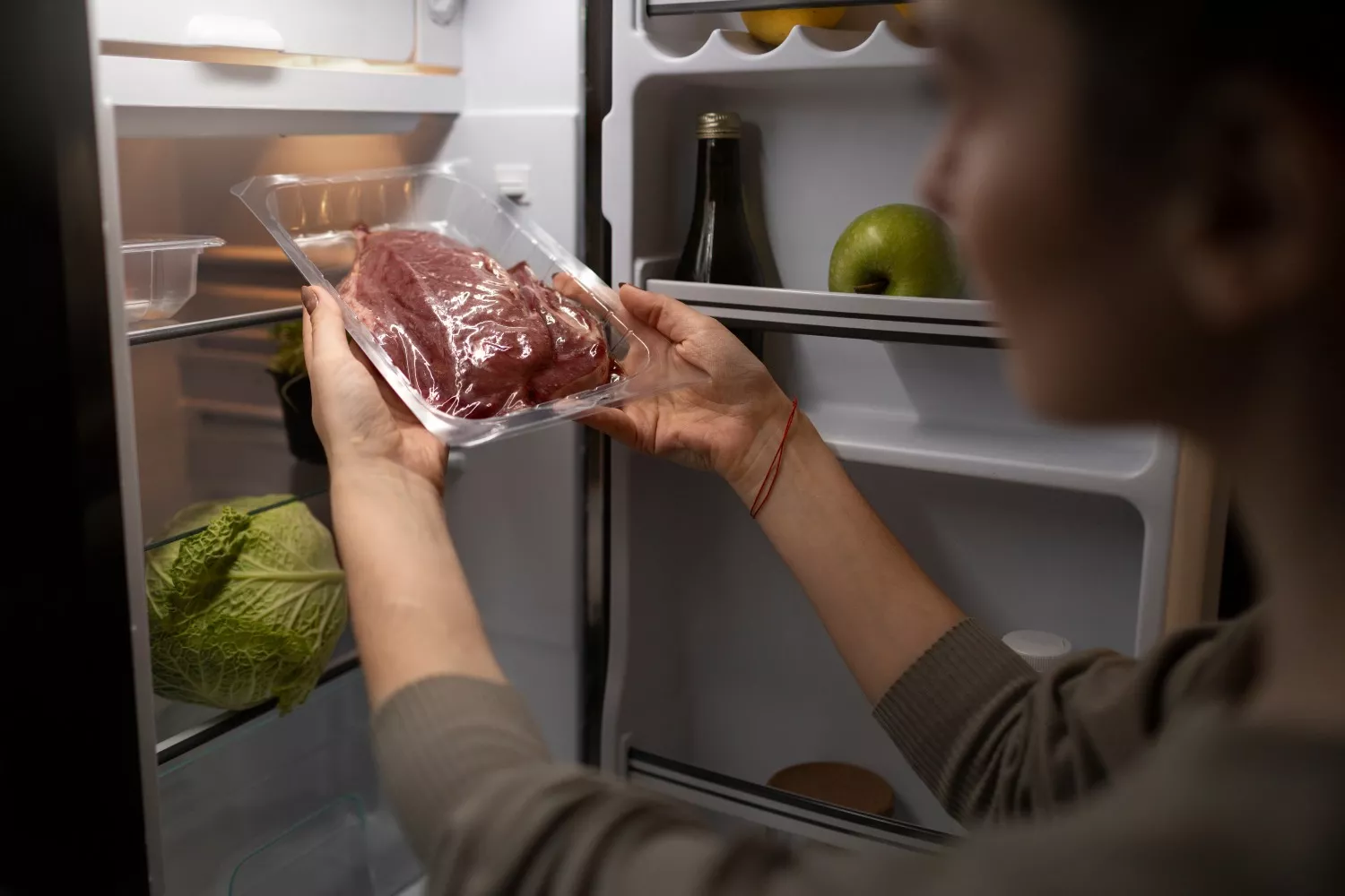 Una persona guarda un corte de carne plastificado/ FREEPIK