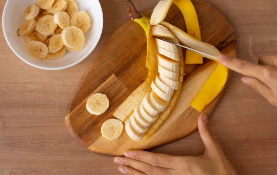 Una persona corta un plátano / FREEPIK Una persona corta un plátano / FREEPIK