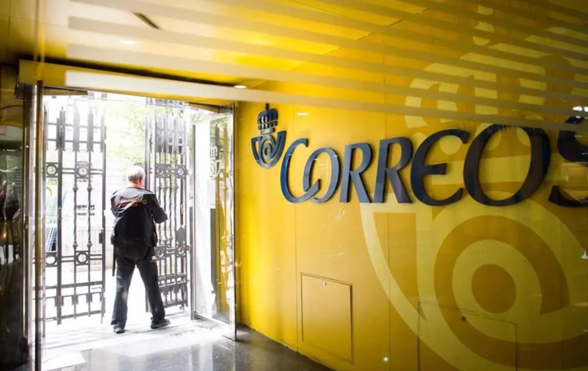 Un vigilante maneja el cierre metálico de una oficina de Correos / EFE Un vigilante maneja el cierre metálico de una oficina de Correos / EFE
