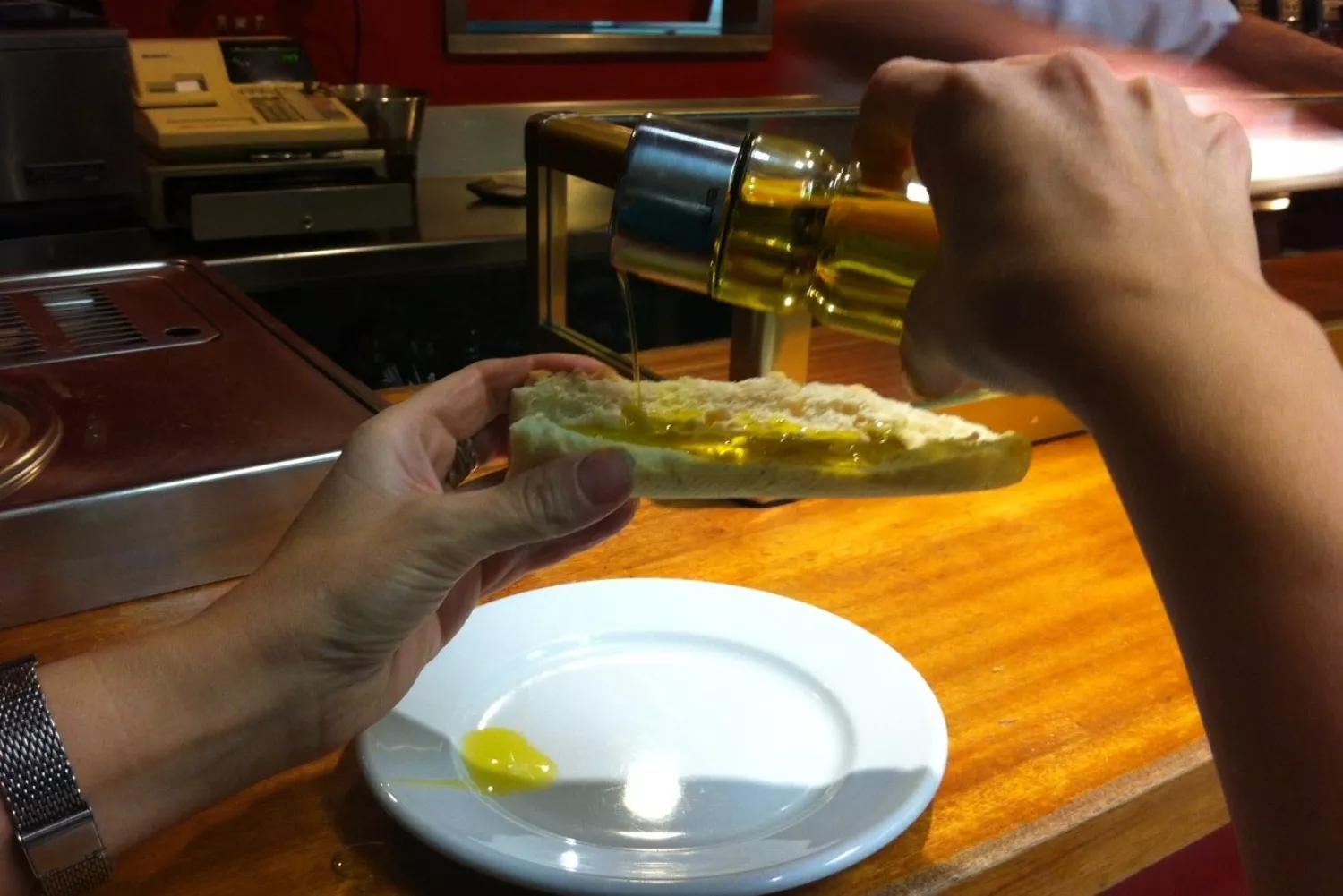 Una persona pone aceite de oliva de una aceitera/ JJRÍOS - EFE