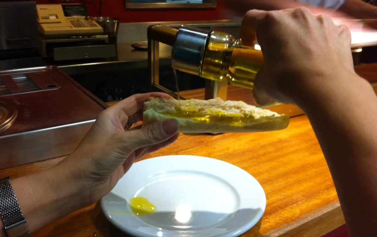 Una persona pone aceite de oliva de una aceitera rellenable en un bar / JJRÍOS - EFE Una persona pone aceite de oliva de una aceitera rellenable en un bar / JJRÍOS - EFE