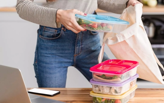 Una mujer coge un túper para llevárselo al trabajo sin refrigerar / FREEPIK Una mujer coge un túper para llevárselo al trabajo sin refrigerar / FREEPIK