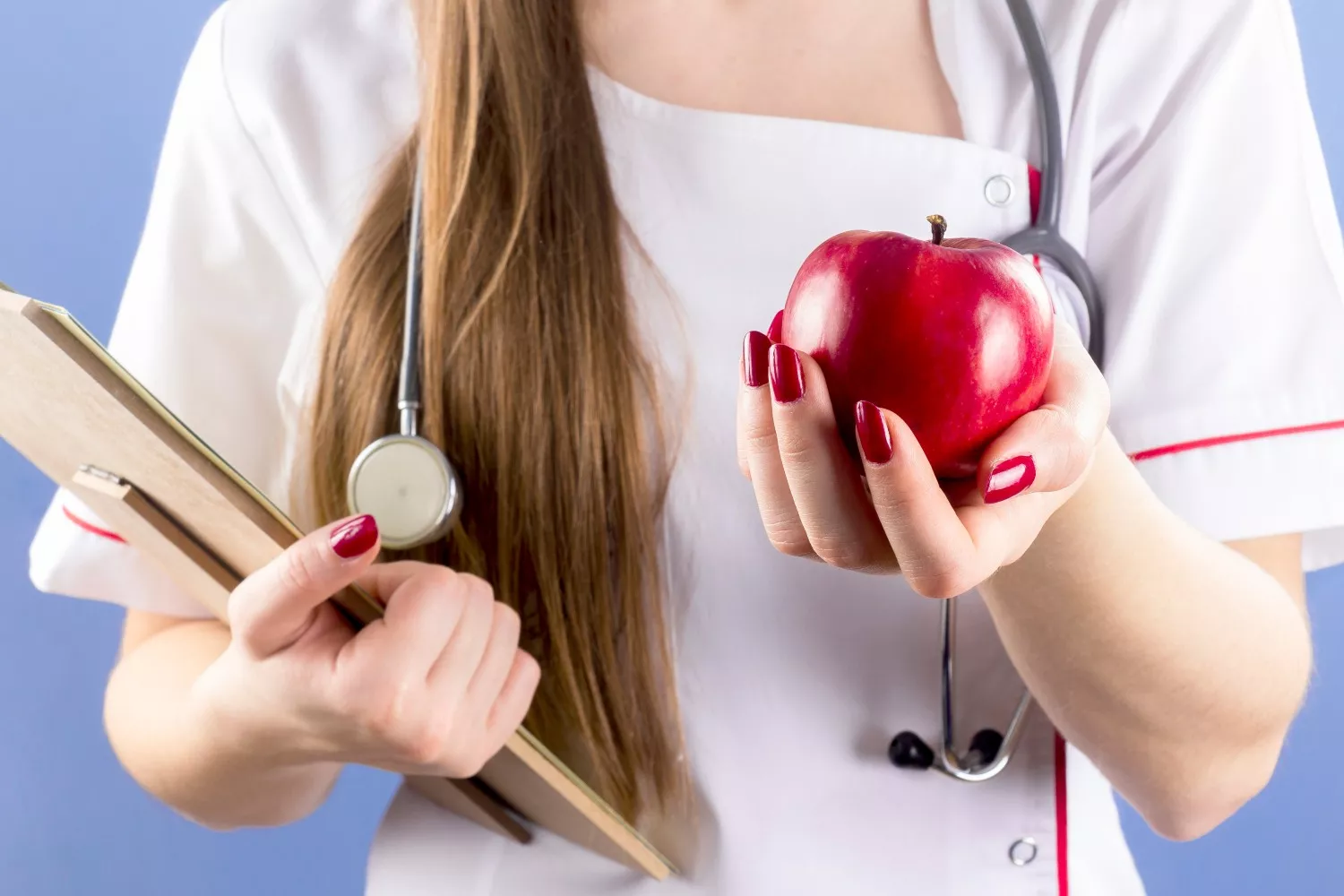 Una experta sostiene una manzana, que puede ayudar a reducir el mal aliento / FREEPIK
