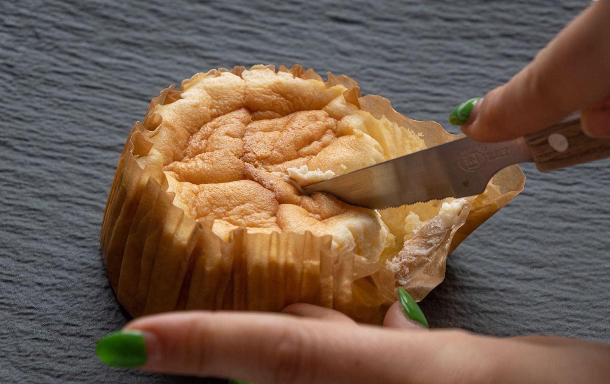 Una mano que parte la tarta de queso de Mercadona / CONSUMIDOR GLOBAL Una mano que parte la tarta de queso de Mercadona / CONSUMIDOR GLOBAL
