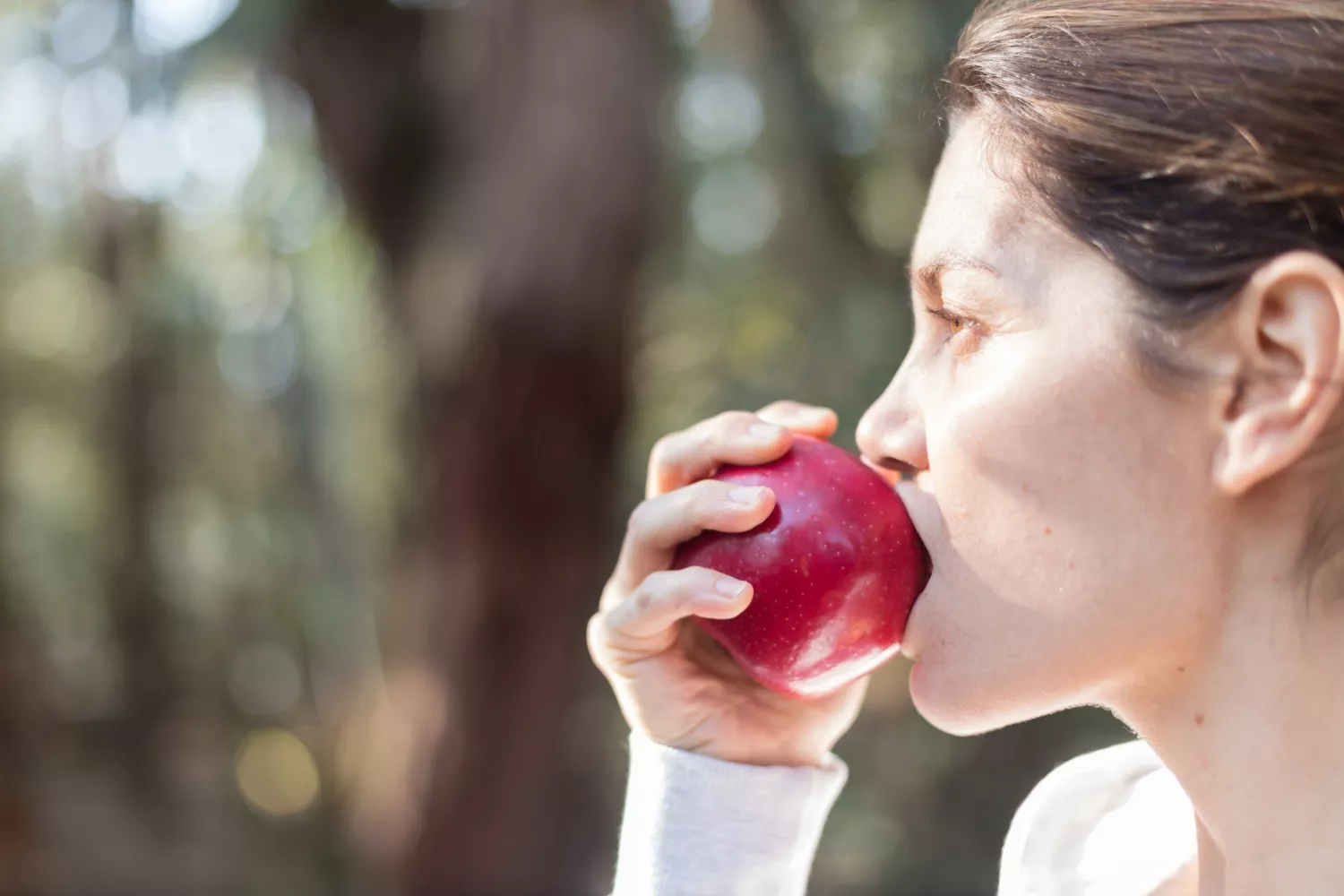 Una persona muerde una manzana / FREEPIK
