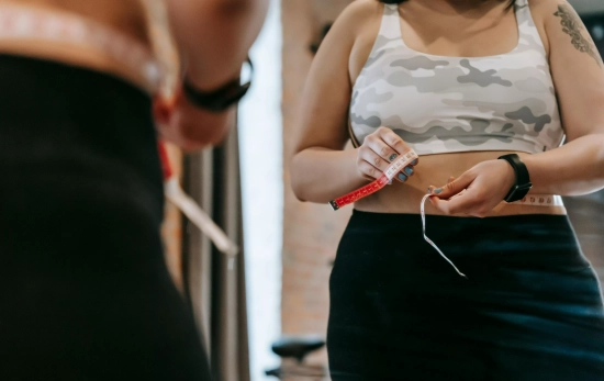 Una chica midiéndose el contorno abdominal/ PEXELS Una chica midiéndose el contorno abdominal/ PEXELS